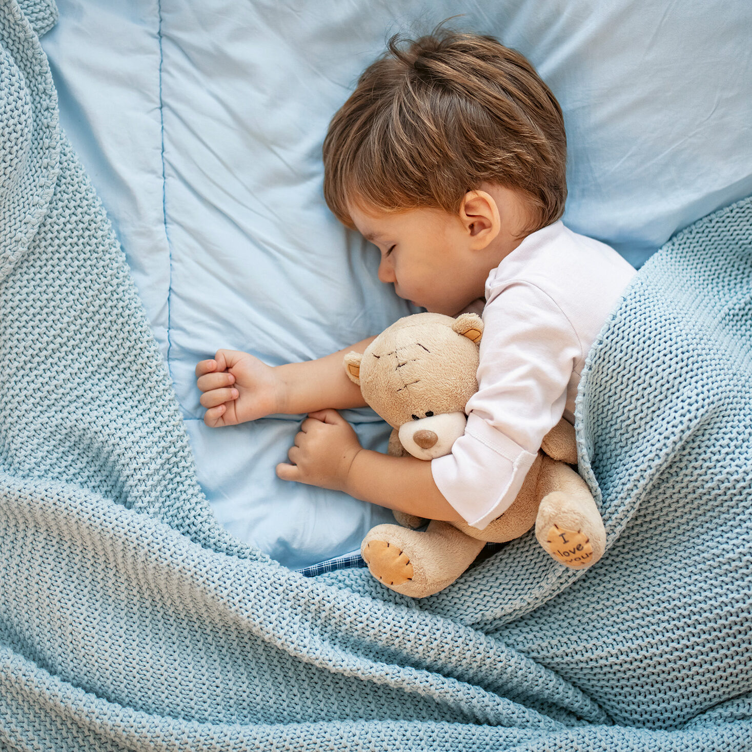 Sweet little boy sleeps with a toy. Young boy in bed sleeping and hug teddy bear. Little boy, big dreamer. It’s bedtime for baby and bear. With teddy close by he has the softest sweetest dreams